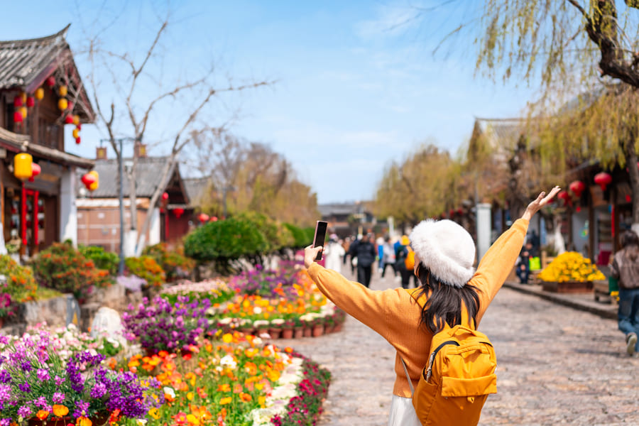 Una joven turista disfrutando de un viaje e la Ciudad Antigua de Lijiang, un famoso destino turistico en la provincia de Yunnan, China